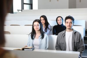 Four diverse university students seated together in a lecture hall