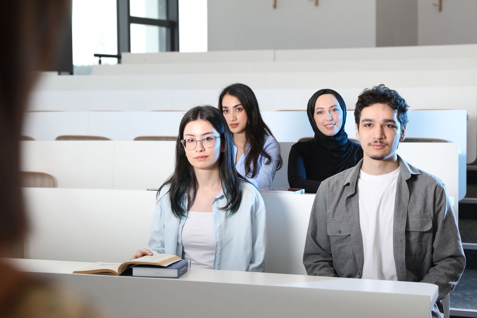Four diverse university students seated together in a lecture hall